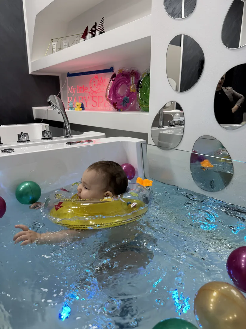 Beba Iskra pluta u plavo osvetljenoj hidro-kadici — baby spa Pančevo