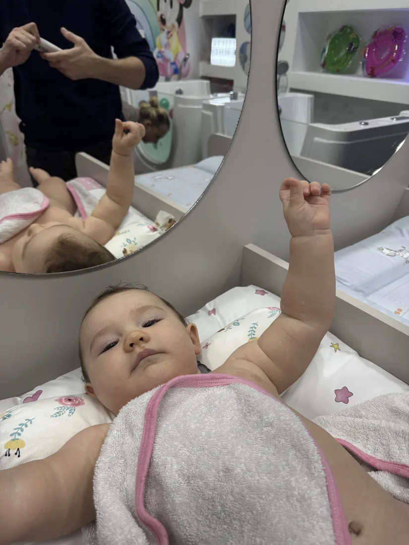 Beba pokreće ruke i noge u toploj vodi i jača mišiće — baby spa Pančevo