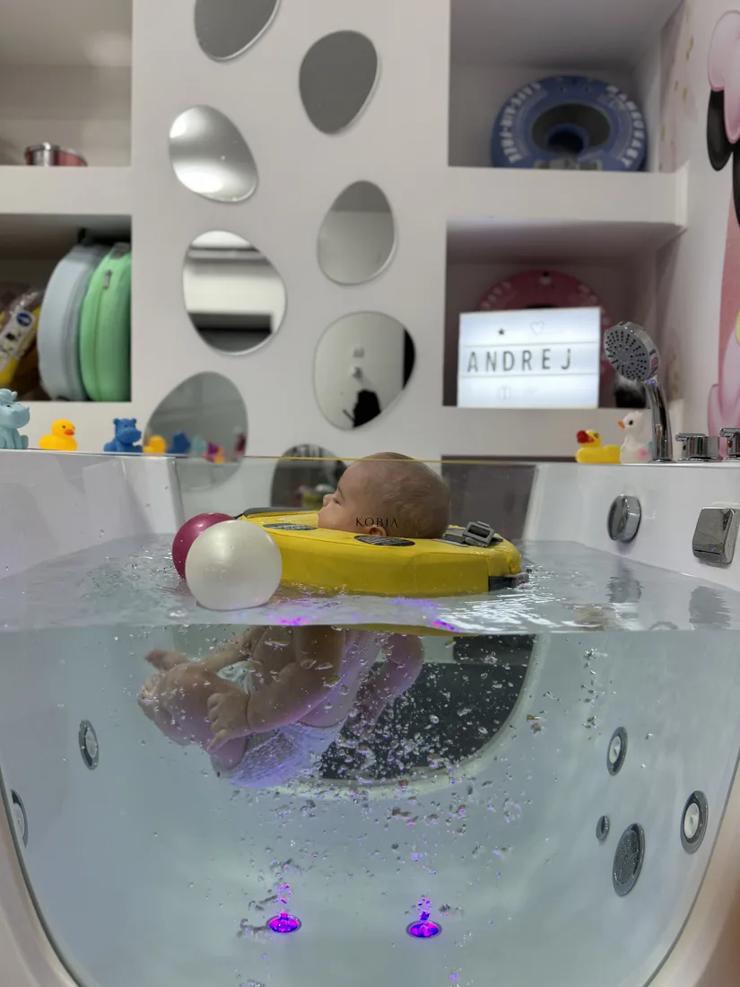 Beba nežno pokreće nožice u toploj vodi — baby spa Pančevo
